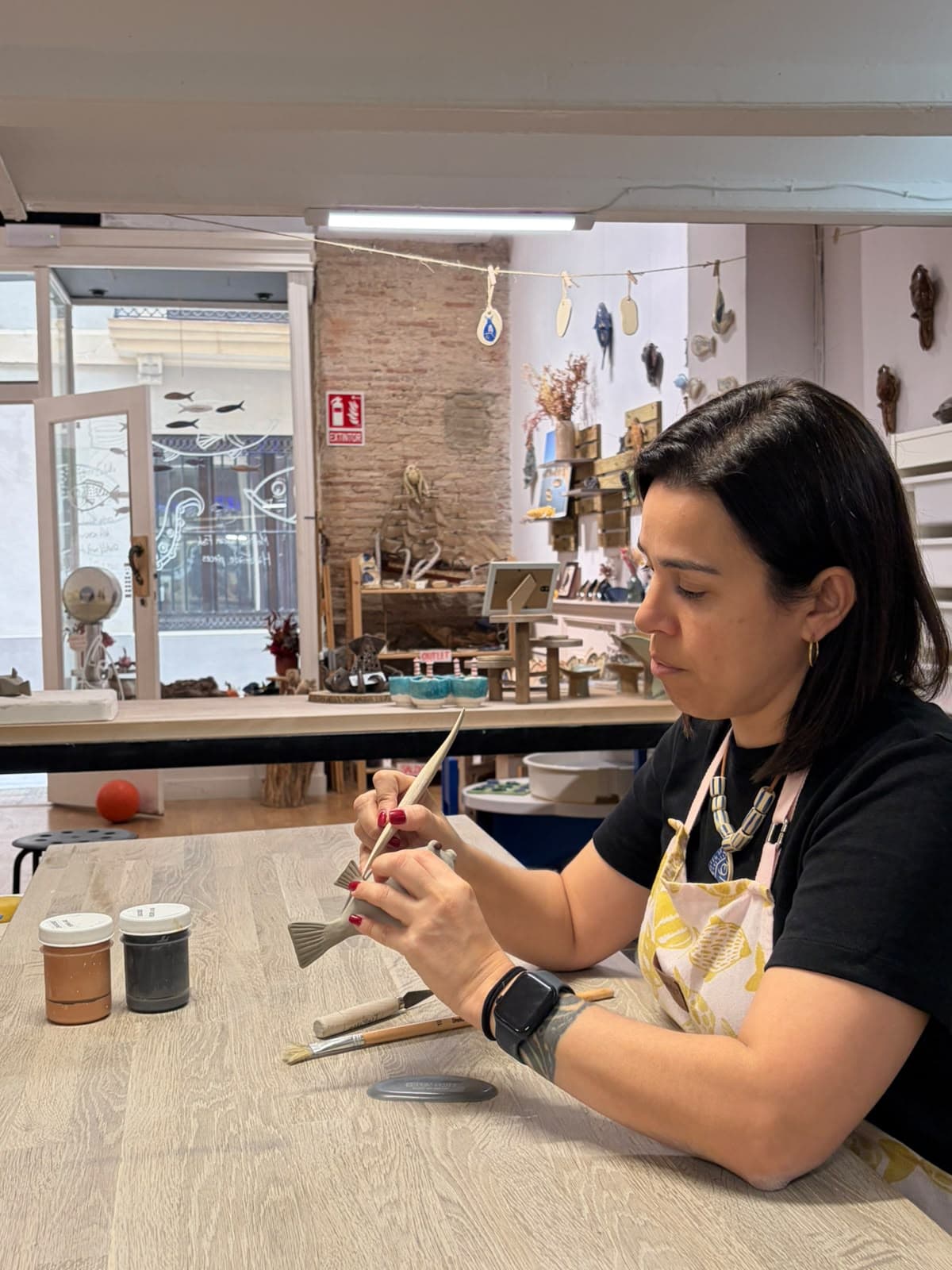 Yoli Amaro pintando una pieza de cerámica en su taller